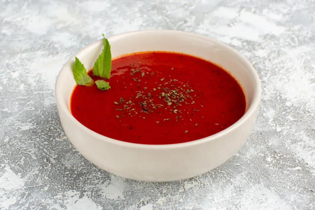 Easy Tomato Soup Recipe: Steaming bowl of homemade tomato soup with basil garnish
